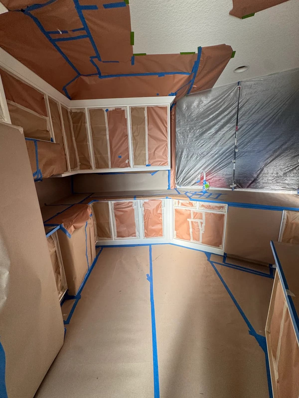 Whole kitchen masked and sheeted before spraying begins