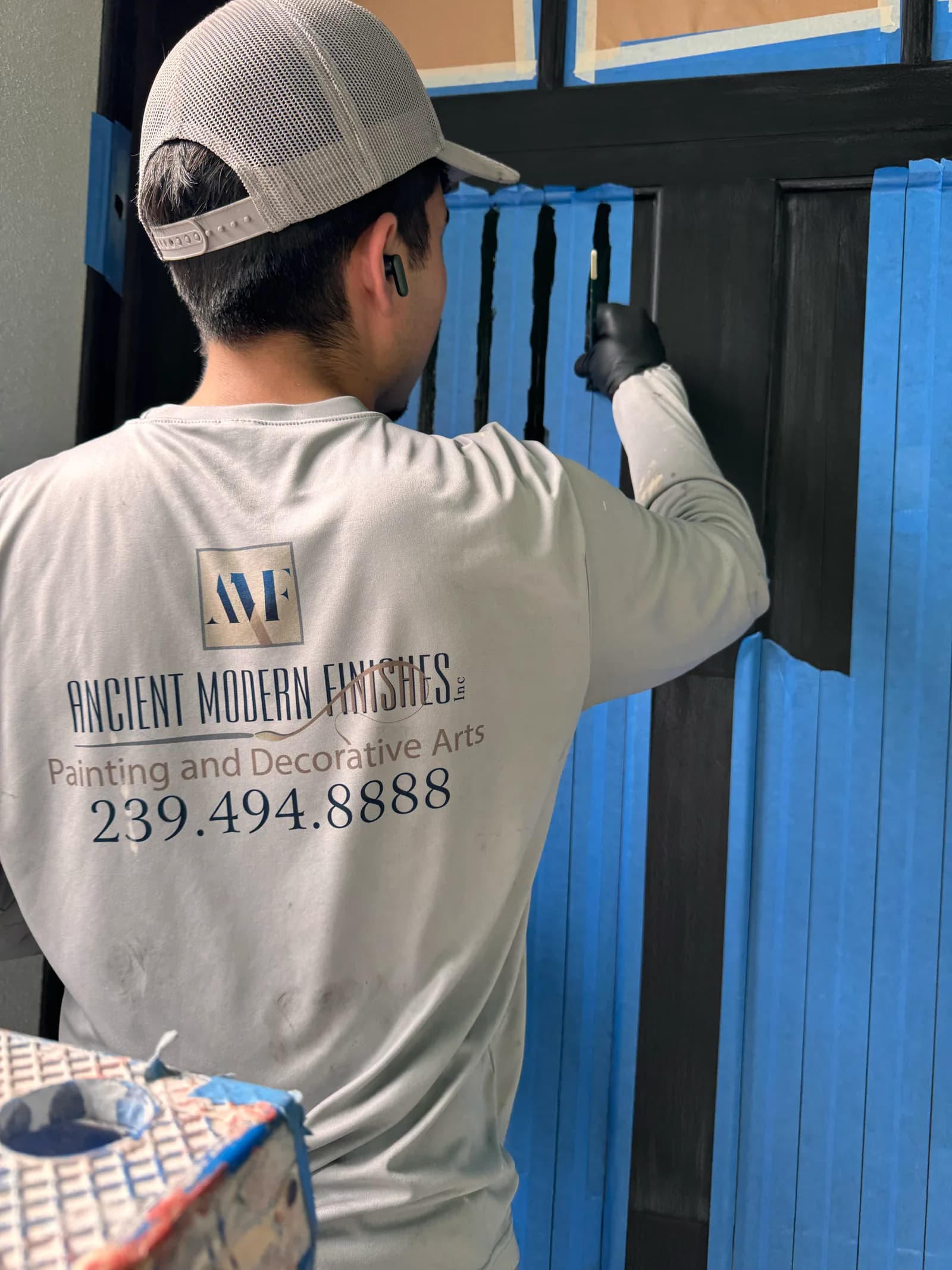 Crew member in a branded work shirt cutting in a door panel by hand