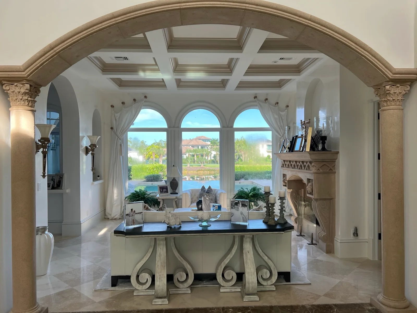 Great room with a coffered ceiling and arched window wall