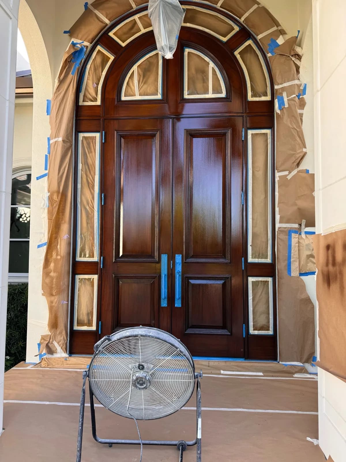 Mahogany entry doors masked off part way through refinishing
