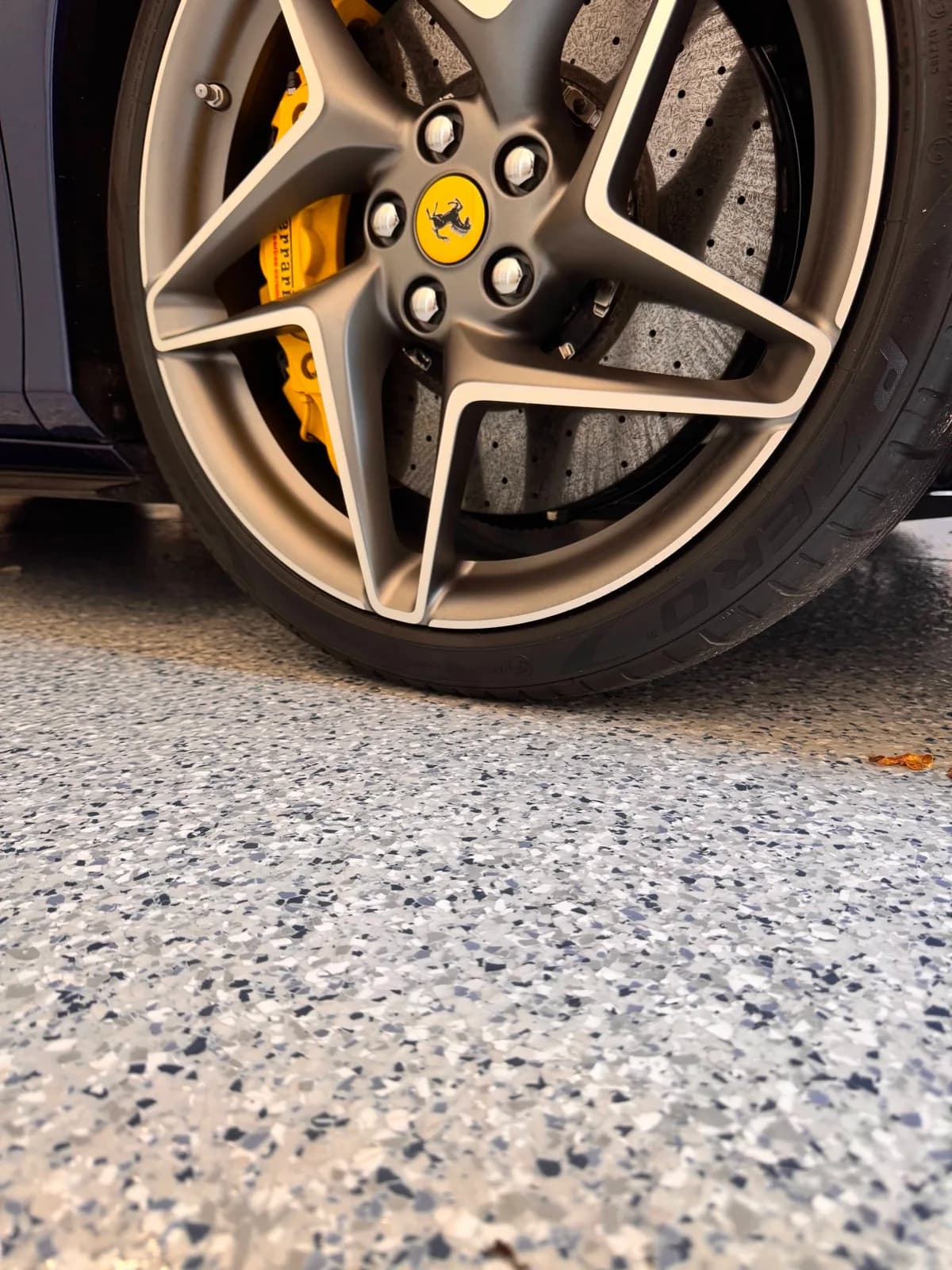 Sports car wheel resting on a finished flake epoxy floor