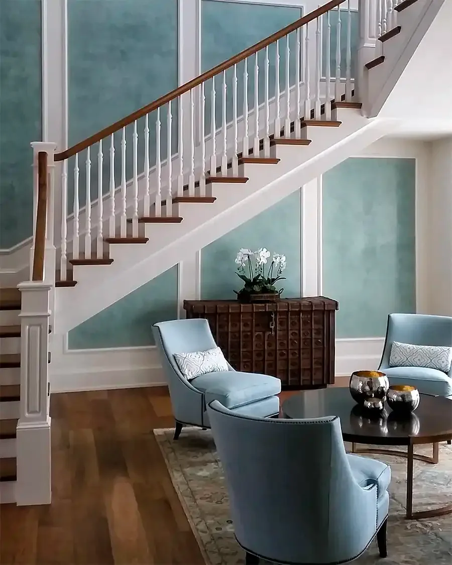 Staircase hall painted in soft teal with white balustrade