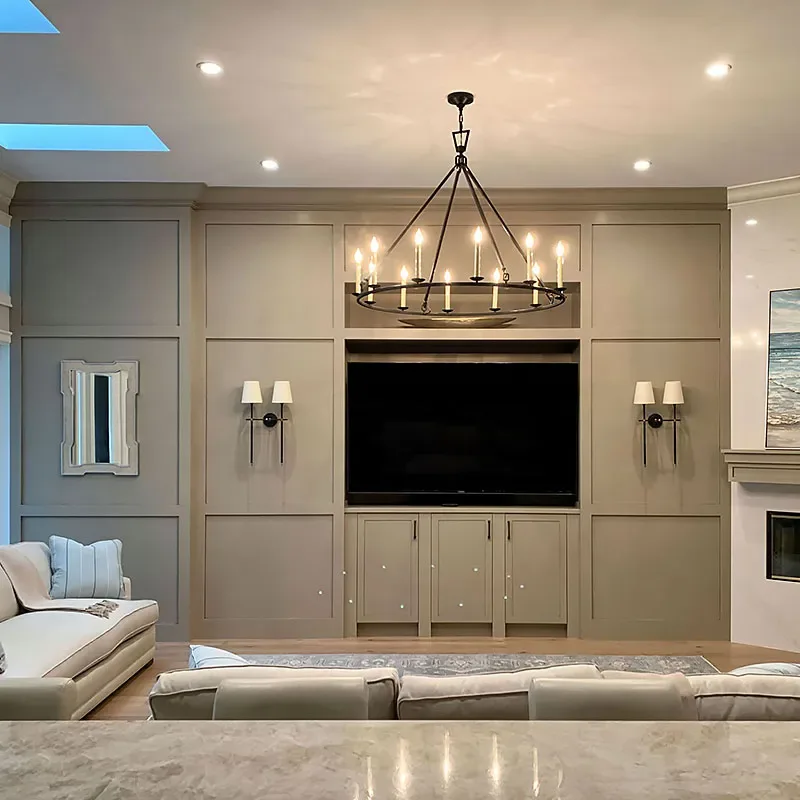 Living room with a painted built-in media wall and chandelier