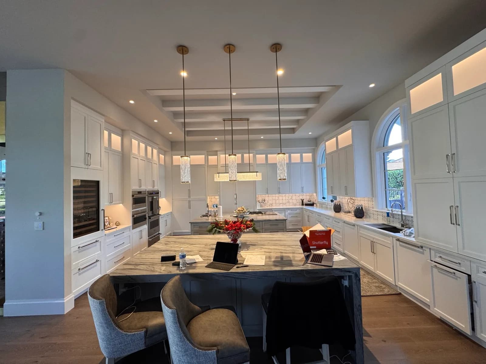 White kitchen with pendant lights over a dark island