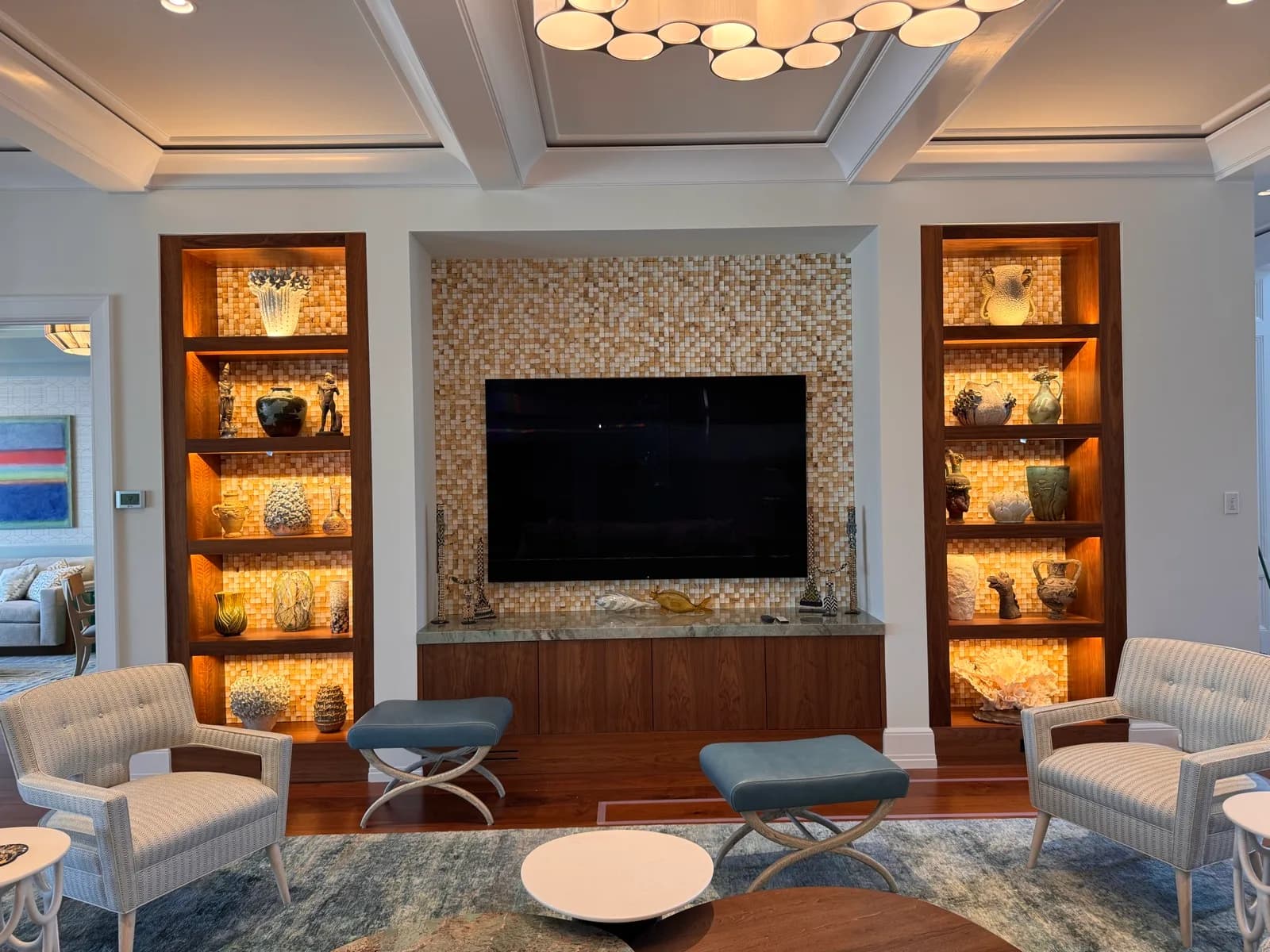 Media wall with lit display niches and painted cabinetry